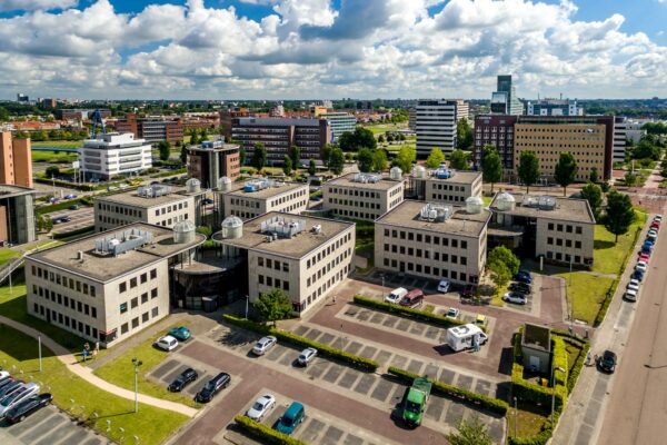 Luchtfoto van kantoorgebouwen aan de Rivium 1e Straat in Capelle aan den IJssel met omliggende parkeerterreinen en stedelijke omgeving.